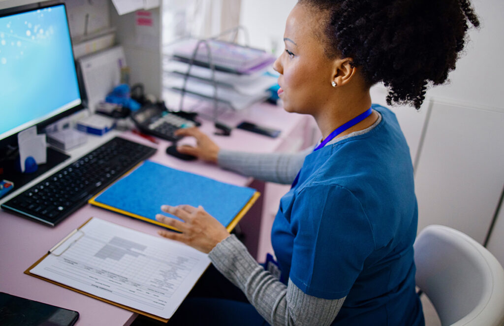medical worker with file using computer 1394002689 1200 776