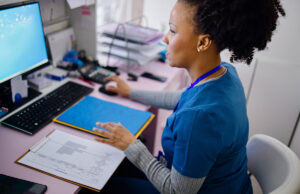 medical worker with file using computer 1394002689 1200 776