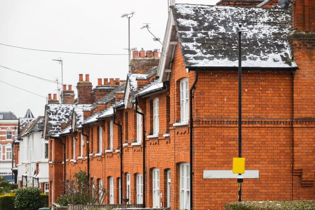 Row of brick townhomes with dusting of snow on rooves.