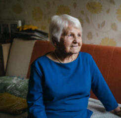 contemplative senior woman smiling on couch