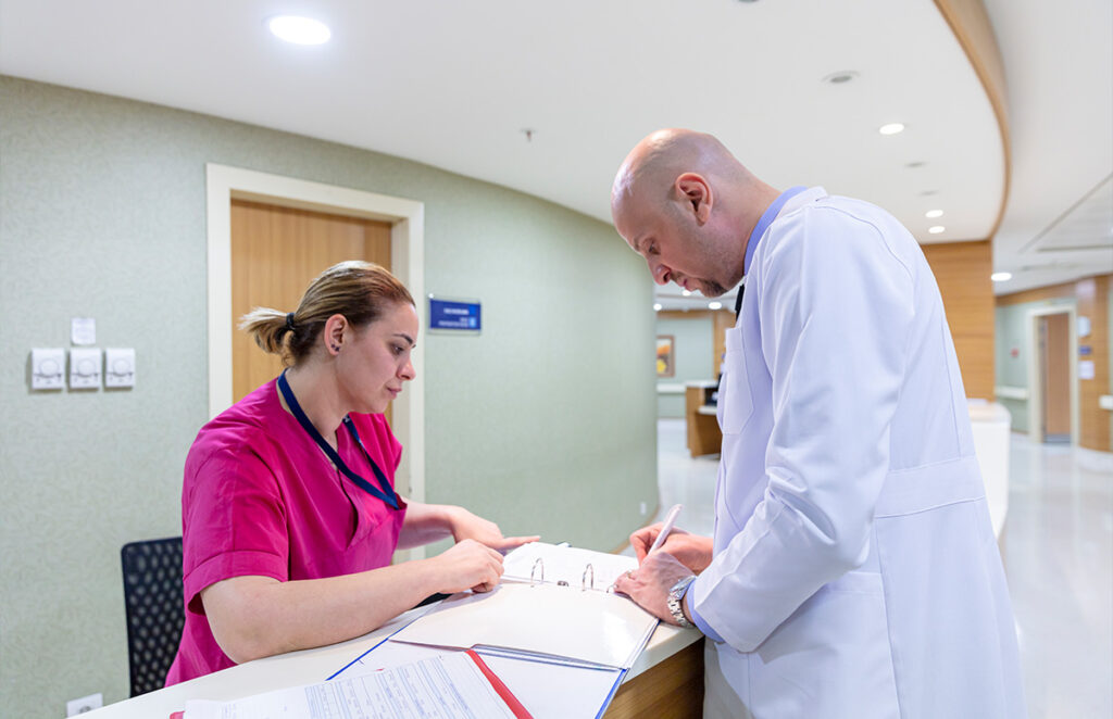 doctor and nurse reviewing files in hospital 1358903030 1200 776