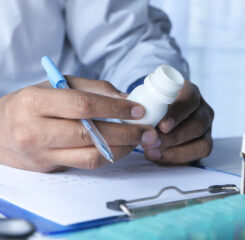 doctor filling pill container with medication 1200 776