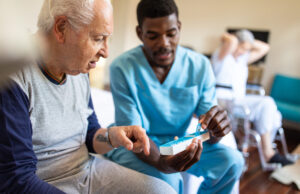 elderly man speaking with caretaker 1207050363 1200 776