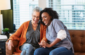 elderly woman and caretaker smiling and laughing together 1394711367 1200 776
