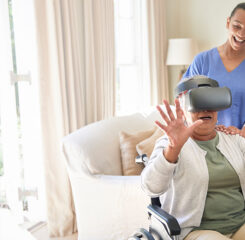 elderly woman receiving virtual reality therapy in wheelchair with caretaker 1277580990 1200 776