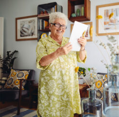 elderly woman smiling holding tablet 1170715657 1200 776