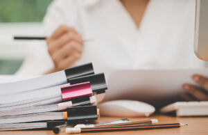 stack of files with woman reading 1136513274 1200 776