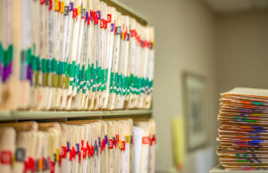 stack of medical files in office 1200 776