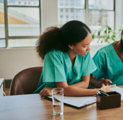 two medical workers reading files discussing 1500306553 1200 776