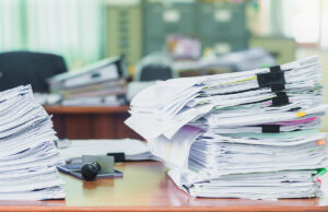 two stacks of files on desk 1161940000 1200 776