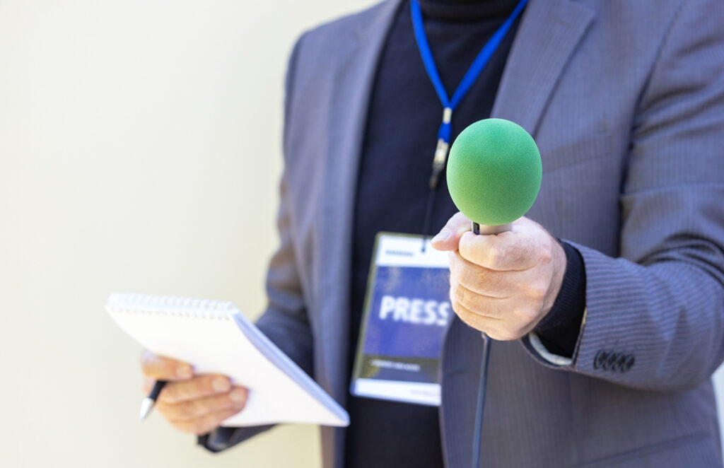 Correspondent holding microphone making media interview