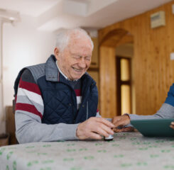 Smiling retired man with female home carer