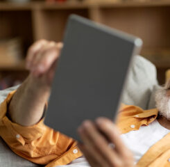 cheerful senior man using digital tablet at home 1200 776