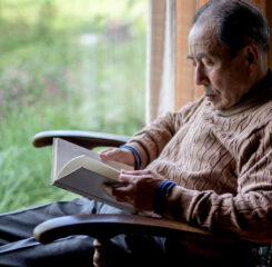 elderly man sitting in rocking chair by a window 1200 776