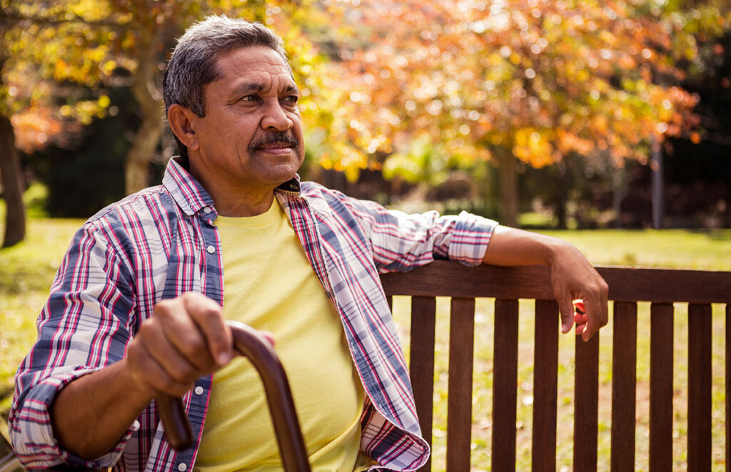 elderly man sitting on the bench with his cane 1200 776
