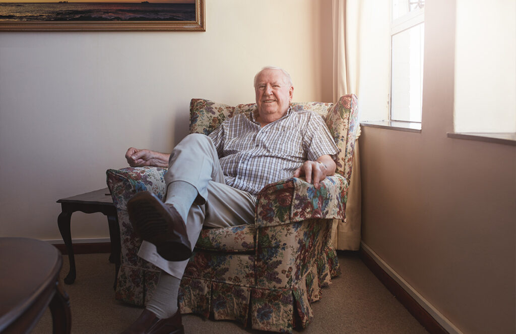 relaxed elderly man sitting on an armchair 1200 776