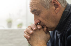 senior man privately praying 1200 776