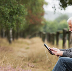 senior man using digital tablet outdoors 1200 776