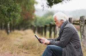 senior man using digital tablet outdoors 1200 776