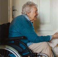 senior woman on wheelchair enjoying time with her dog 1200 776