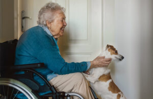 senior woman on wheelchair enjoying time with her dog 1200 776