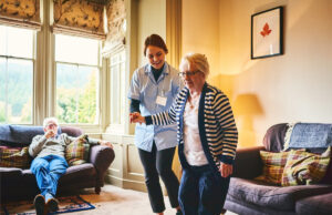 Caregiver assisting resident walking 968995164 1200 776