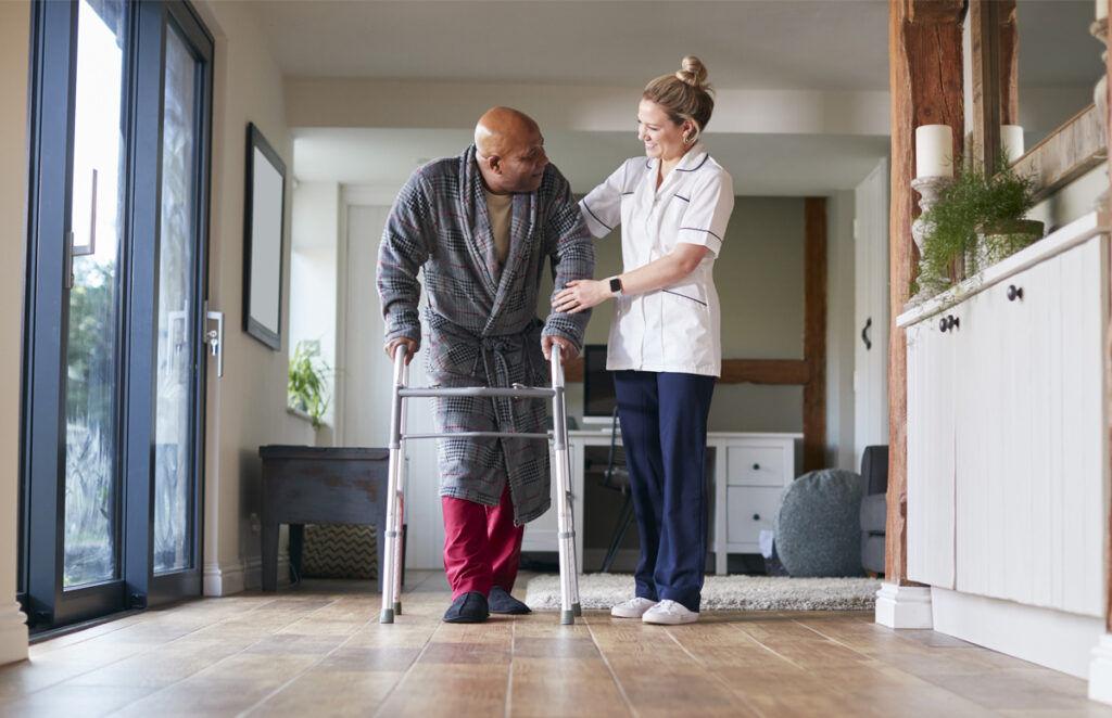 Caregiver helping resident walk 1282867645 1200 776