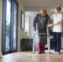 Caregiver helping resident walk 1282867645 1200 776