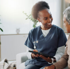 Caregiver showing IPad to resident 2153405378 1200 776