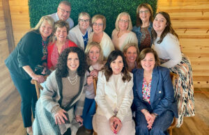 Lynne Giacobbe surrounded by staff members May26 1200 776